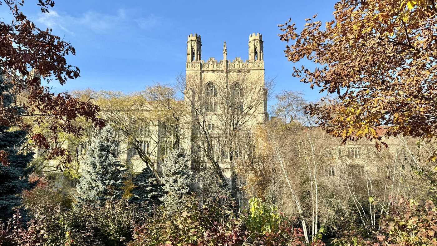 Harper Memorial Library towers above autumn trees on the University of Chicago campus